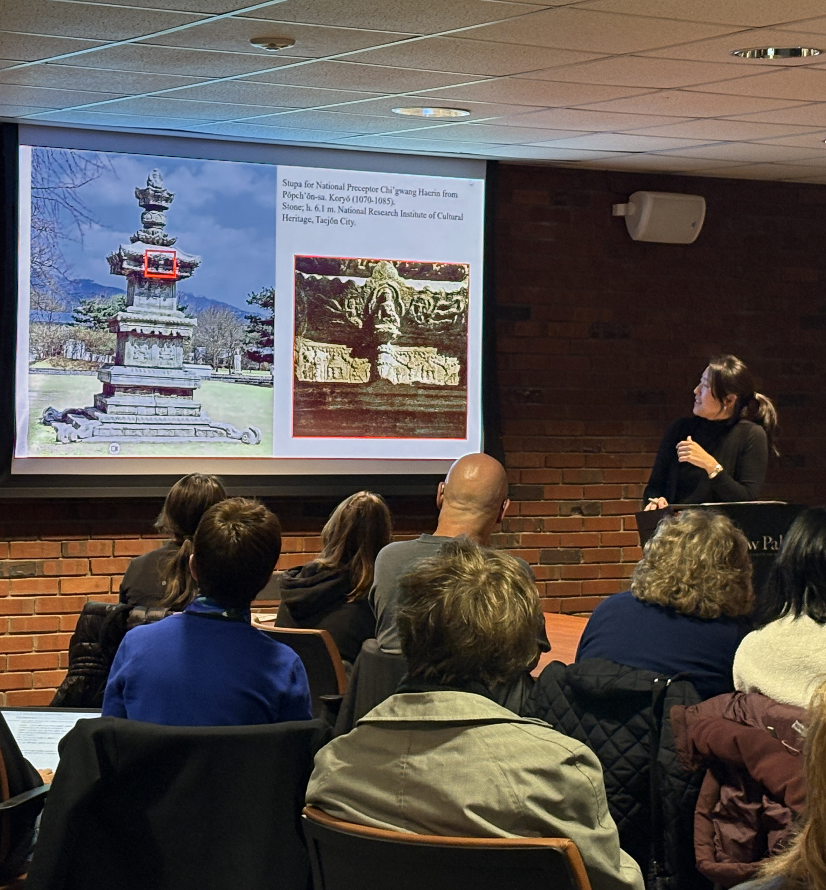 a Professor of Asian Art, presenting a lecture, a stupa is shown on the screen